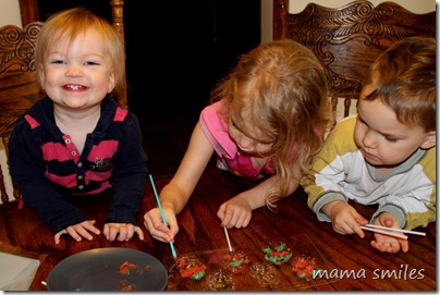 Emma adds details to her candy melt snowman (and Lily hams it up for the camera)