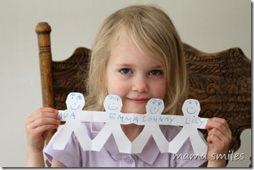 Emma showing off her paper doll chain