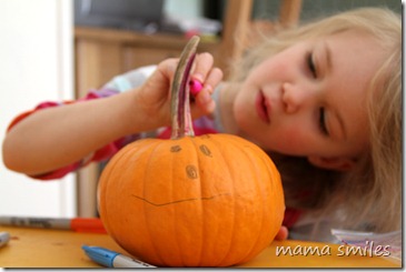 Emma decorates a small pumpkin