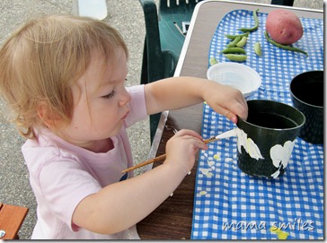 Lily paints a pot at the farmer's market
