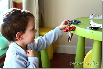 Johnny uses tape to create dramatic play scenes with his cars