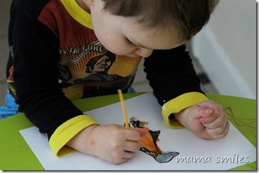 Johnny paints in a hand-drawn penguin