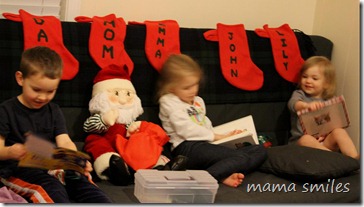 Three kids reading to Santa