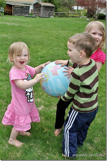 All three kids holding a globe