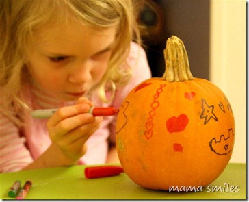 Emma decorates her pumpkin with plenty of artistic intensity