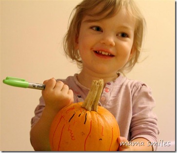 Lily happily decorating her pumpkin