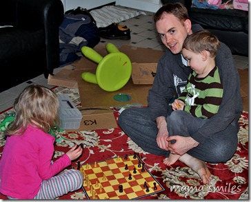 Emma and Johnny play chess with their dad 