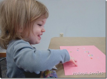 Lily puts sticker on paper