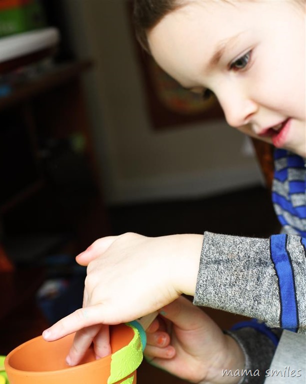 five-year-old adds finishing touches to his terra cotta clay pot