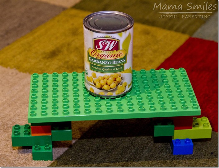 Bridge STEM challenge for kids: design a bridge that can hold a can of food.